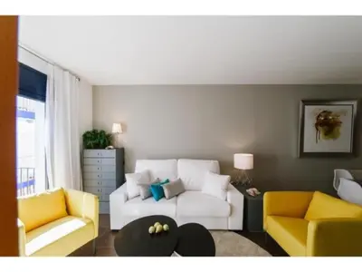 a living room with a white couch and yellow chairs at Sitges Spaces Deluxe Beach Apartment- 3 Bedroom, 2 Bathroom, Next to Beach, Sleeps 6 in Sitges