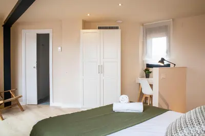 a bedroom with a green bed and a white cabinet at Barcelona Touch Apartments - Progres in Hospitalet de Llobregat