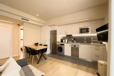 a kitchen with white cabinets and a table in a room at Barcelona Touch Apartments - Progres in Hospitalet de Llobregat