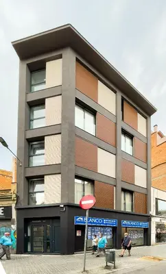 a building with people sitting outside of it at Barcelona Touch Apartments - Progres in Hospitalet de Llobregat