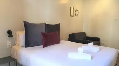 a bedroom with a bed with two pillows and a chair at Barrio Gotico Apartments Ferran in Barcelona
