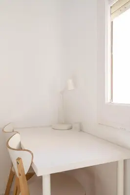 a white desk with a chair next to a window at Apartamento NUEVO con encanto en SAGRADA FAMILIA in Barcelona