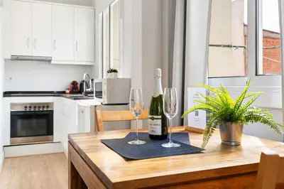 a kitchen with a wooden table with two wine glasses at Lodging Apartments Barceloneta Beach Studio 42 in Barcelona
