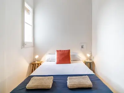 a bedroom with a bed with two towels on it at White penthouse in Barcelona