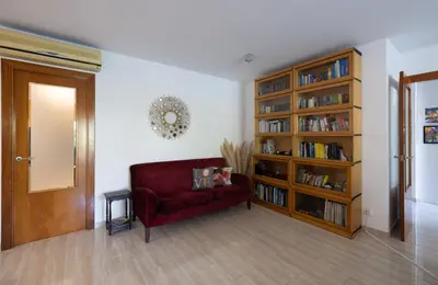 a living room with a red couch and a book shelf at Stay U-nique Villa Portimar in Arenys de Mar