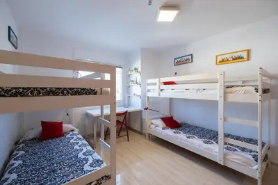 a room with three bunk beds and a desk at Stay U-nique Villa Portimar in Arenys de Mar