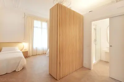 a bedroom with a bed and a large wooden partition at The MO House in Barcelona