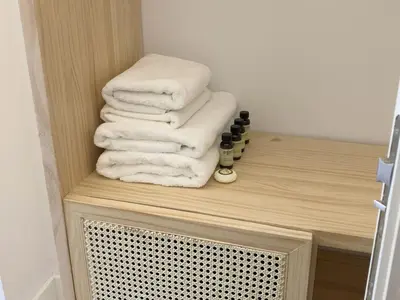 a stack of towels sitting on a shelf in a bathroom at The MO House in Barcelona