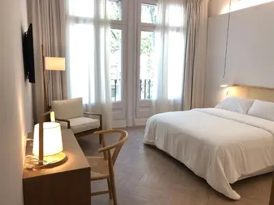 a bedroom with a bed and a table and a chair at The MO House in Barcelona