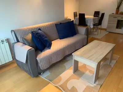 a living room with a couch and a table at APARTAMENTO construcción nueva BARCELONA - CALELLA in Calella