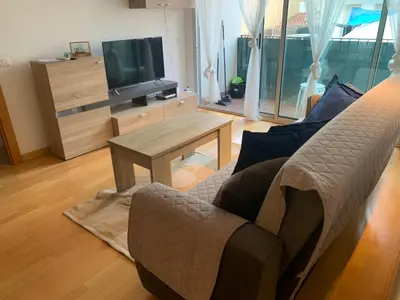 a living room with a couch and a tv at APARTAMENTO construcción nueva BARCELONA - CALELLA in Calella