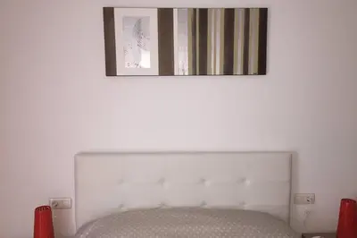 a picture hanging above a bed in a room at APARTAMENTO construcción nueva BARCELONA - CALELLA in Calella