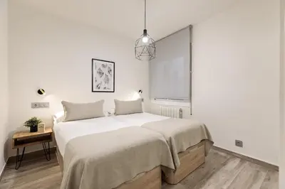 a bedroom with a large bed with white sheets at Sitges Group Blue&White in Sitges