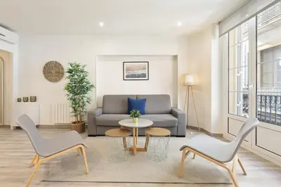 a living room with a couch and a table and chairs at Sitges Group Blue&White in Sitges