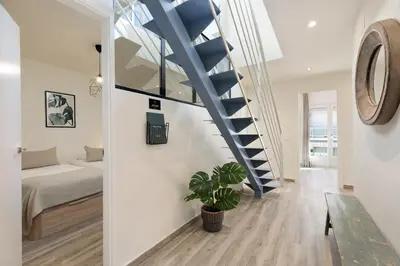 a staircase in a room with a bed and a couch at Sitges Group Blue&White in Sitges