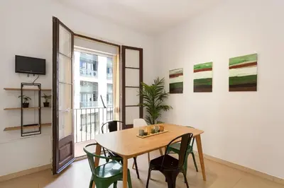 a dining room with a table and chairs and a window at Stay U-nique Apartments Mistral in Barcelona