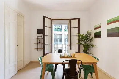 a dining room with a wooden table and chairs at Stay U-nique Apartments Mistral in Barcelona