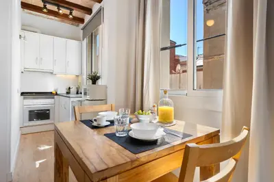 a kitchen with a wooden table and a dining room at Lodging Apartments Barceloneta Beach Studio 32 in Barcelona