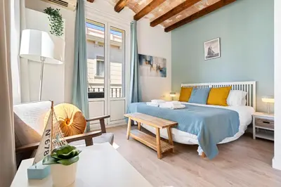a small bedroom with a bed and a table at Lodging Apartments Barceloneta Beach Studio 32 in Barcelona