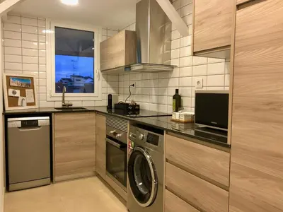 a kitchen with a washing machine and a window at MonResidence Cavall Bernat in Manresa