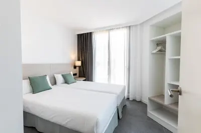a bedroom with a large white bed and a window at Art Apartments BCN in Castelldefels