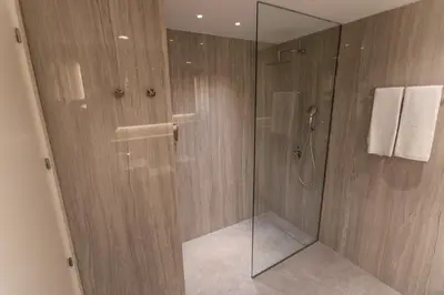 a bathroom with a shower with a glass door at Art Apartments BCN in Castelldefels