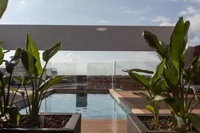 a swimming pool on top of a building with plants at Art Apartments BCN in Castelldefels