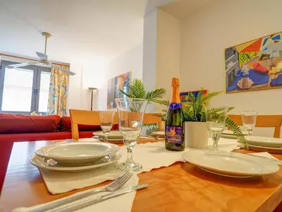a dining room table with plates and a bottle of wine at Apartamento Burdeos by Hello Homes Sitges in Sitges