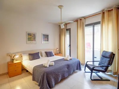 a bedroom with a bed and a chair at Apartamento Burdeos by Hello Homes Sitges in Sitges