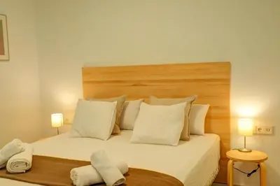 a bedroom with a large white bed with two lamps at Sebastian Patio by Hello Homes Sitges in Sitges