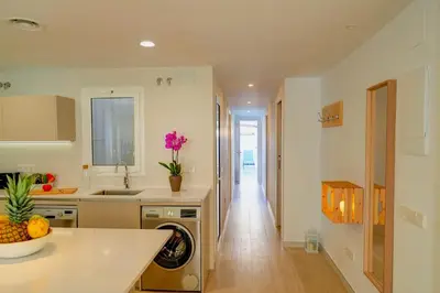 a kitchen with a sink and a washing machine at Sebastian Patio by Hello Homes Sitges in Sitges
