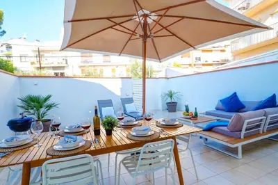 a patio with a table and an umbrella at Sebastian Patio by Hello Homes Sitges in Sitges