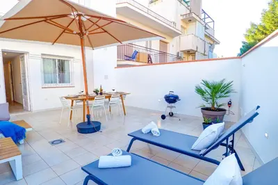 a patio with an umbrella and a table at Sebastian Patio by Hello Homes Sitges in Sitges