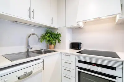 a kitchen with white cabinets and a sink at Lodging Apartments Monumumental in Barcelona