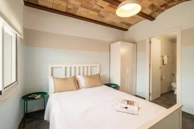a bedroom with a white bed with a book on it at Collblanc Apartment by Olala Homes in Hospitalet de Llobregat
