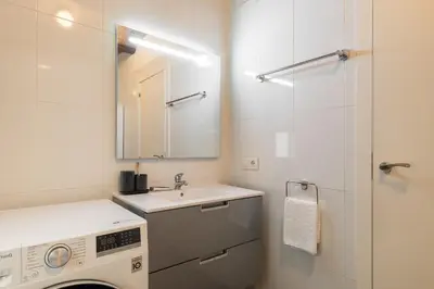 a bathroom with a washing machine and a sink at Collblanc Apartment by Olala Homes in Hospitalet de Llobregat