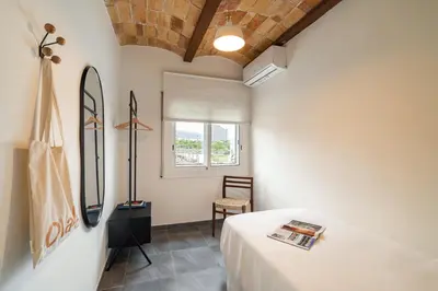 a room with a bed and a chair and a window at Collblanc Apartment by Olala Homes in Hospitalet de Llobregat