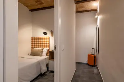 a bedroom with a bed and an orange suitcase at Collblanc Apartment by Olala Homes in Hospitalet de Llobregat