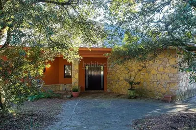a house with a stone wall and a door at El Chalet del Montseny in Seva