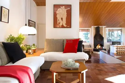 a living room with a white couch and red pillows at El Chalet del Montseny in Seva
