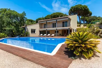 a villa with a swimming pool in front of a house at Mediterranean villa with pool near barcelona in Cabrera de Mar
