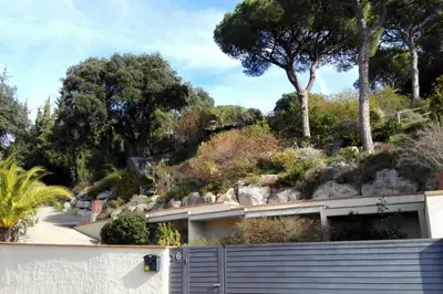 a house with a fence and trees in the background at Mediterranean villa with pool near barcelona in Cabrera de Mar