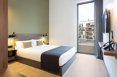 a hotel room with a bed and a large window at Hotel Orangine in Hospitalet de Llobregat