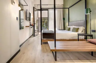 a bedroom with a bed and a table and a couch at Hotel Orangine in Hospitalet de Llobregat