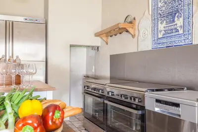 a kitchen with a stove and a bunch of vegetables at Masia Victoria in Sant Pere de Ribes