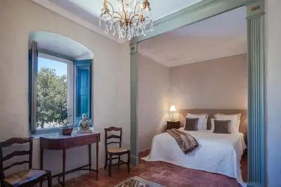 a bedroom with a bed and a desk and a window at Masia Victoria in Sant Pere de Ribes