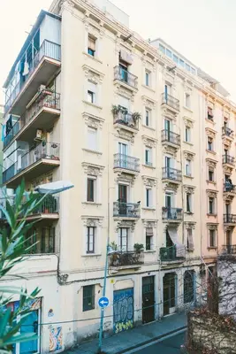 a large white building with balconies on a street at Brummell Apartments Montjuic in Barcelona