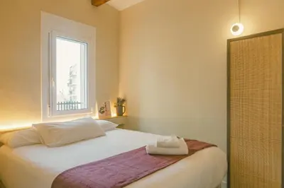 a bedroom with a white bed and a window at Brummell Apartments Montjuic in Barcelona