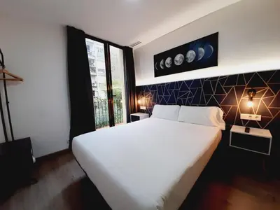a bedroom with a large white bed and a window at Hostal Laia by gaiarooms in Barcelona