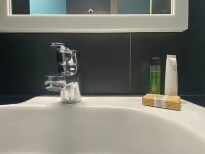 a bathroom sink with a faucet and a toothbrush at Hostal Laia by gaiarooms in Barcelona